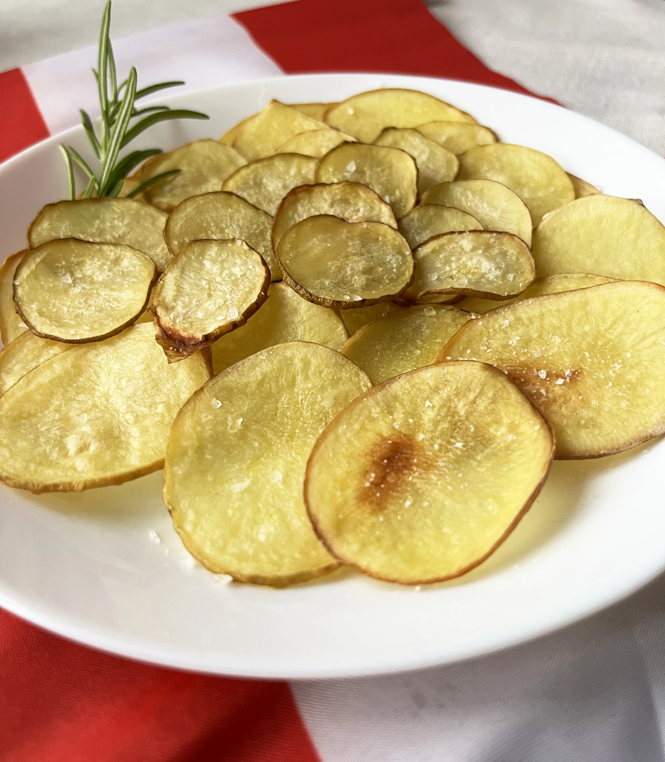 Kartoffelchips auf weißem Teller, der auf einer Österreich-Flagge steht